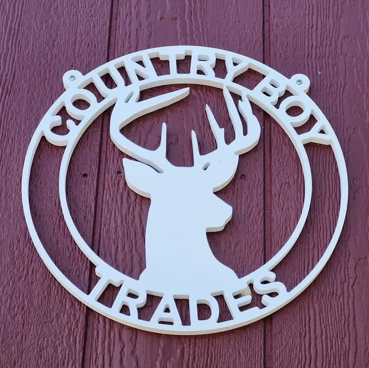 White Country Boy Trades deer-logo sign mounted on barn-red siding.
